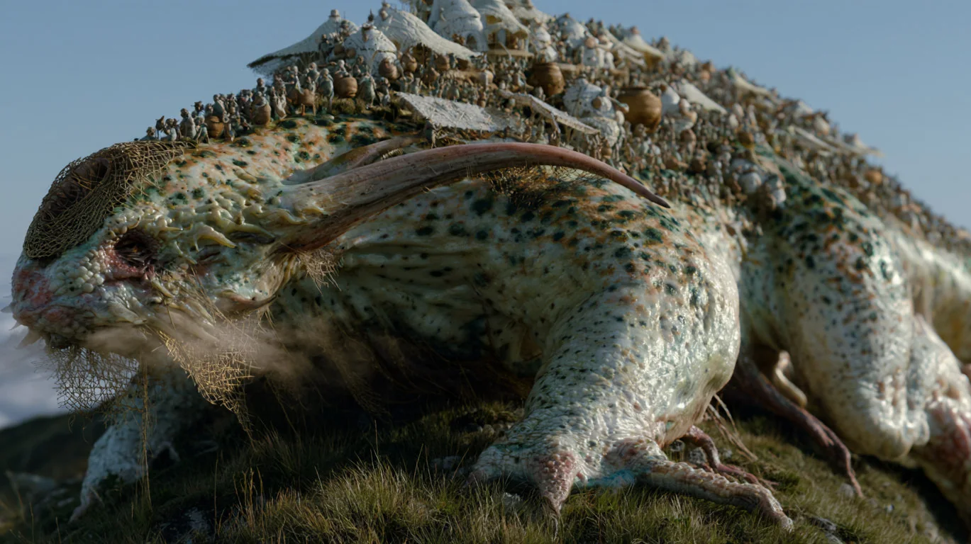 A huge mossy reptile with a small village growing on its back
